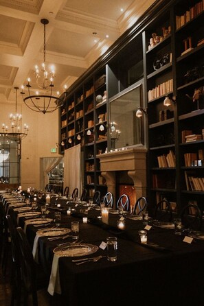 Una larga mesa de comedor adornada con velas, sillas y un candelabro.