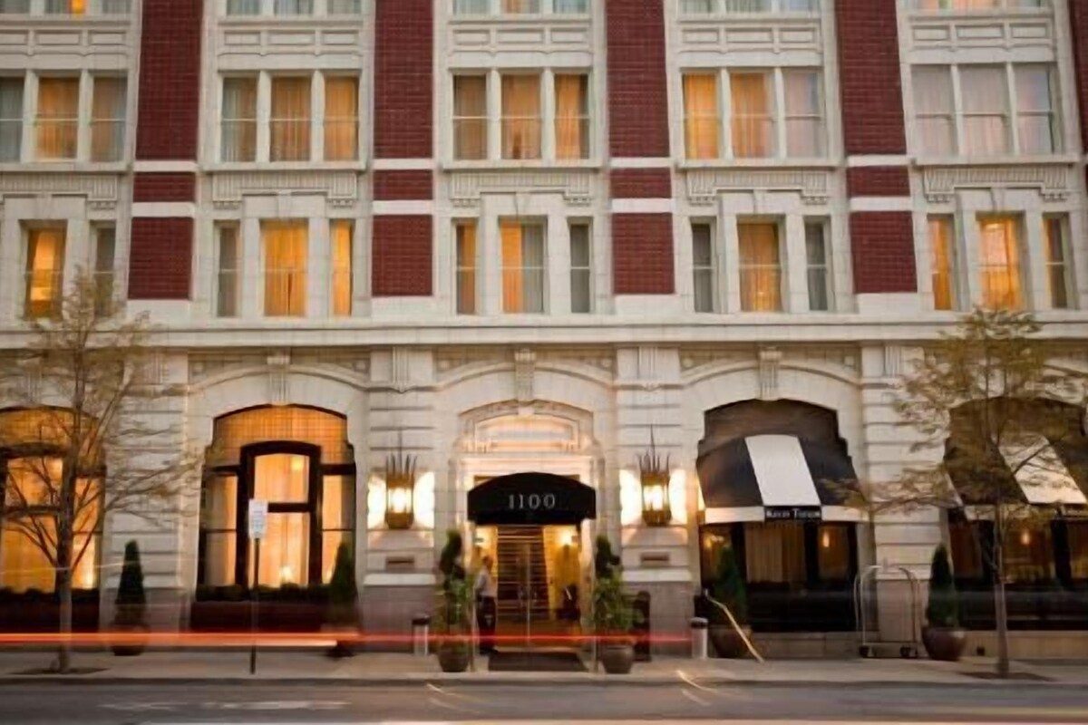 Un hotel con fachada clásica, ventanas amplias y una entrada destacada con un letrero que muestra el número 1100.