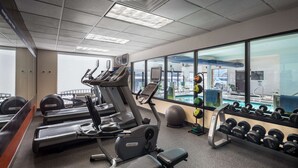 A gym with treadmills, elliptical machines, and a weight rack. - Hampton Inn-Denver West/Golden (Golden)