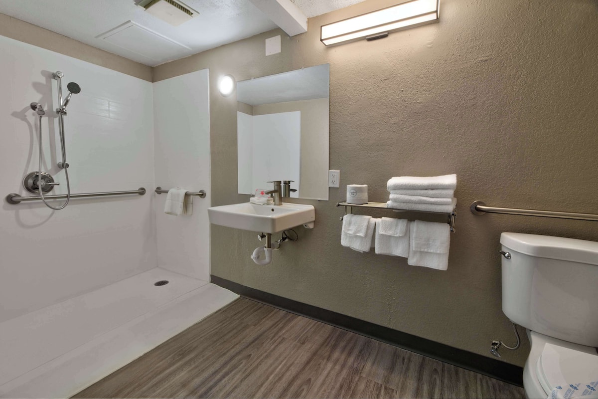 A modern bathroom with a shower, sink, and toilet.