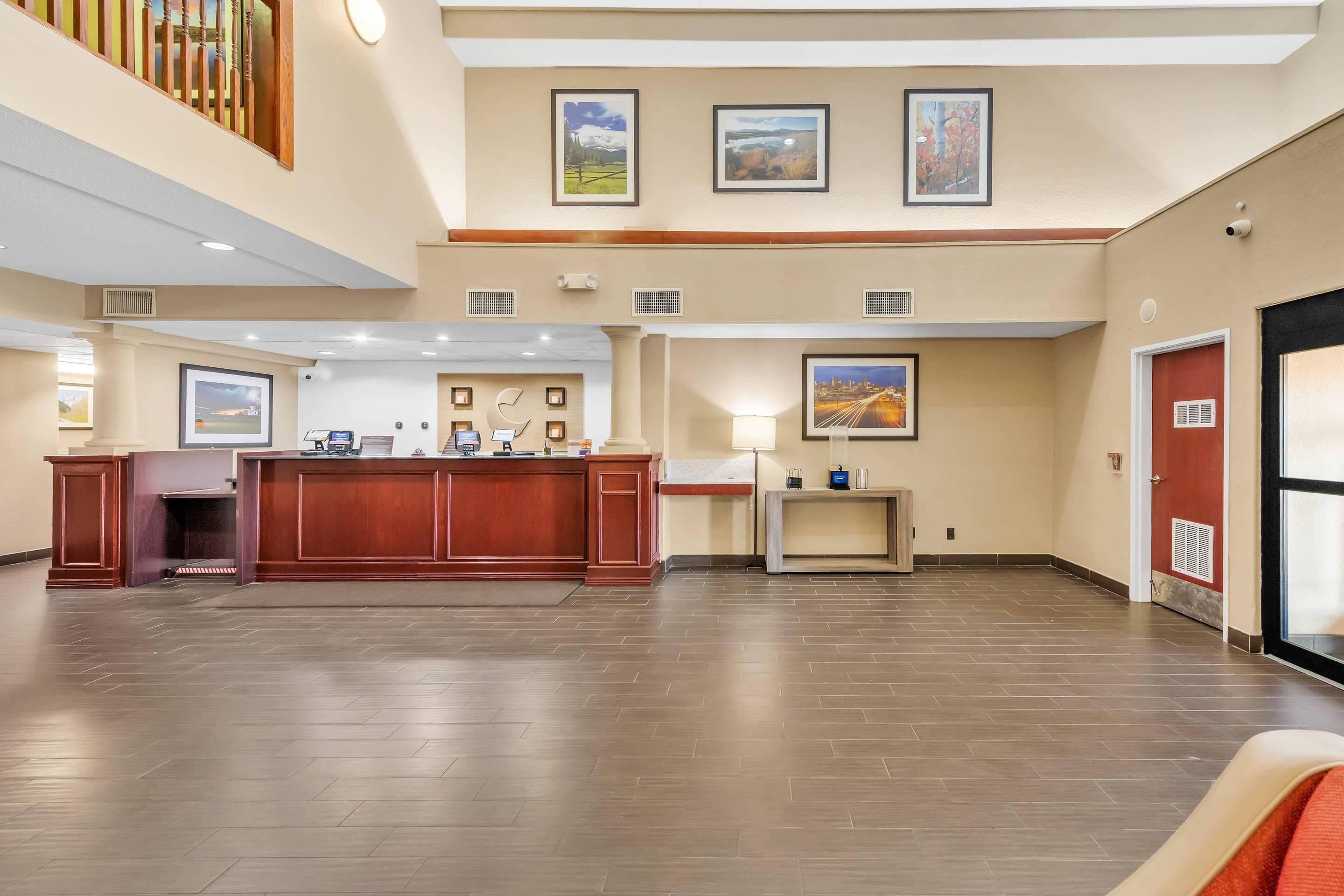 Un vestíbul ampli amb una taquilla d'adreça, obres d'art als murs i un sòl de fusta.