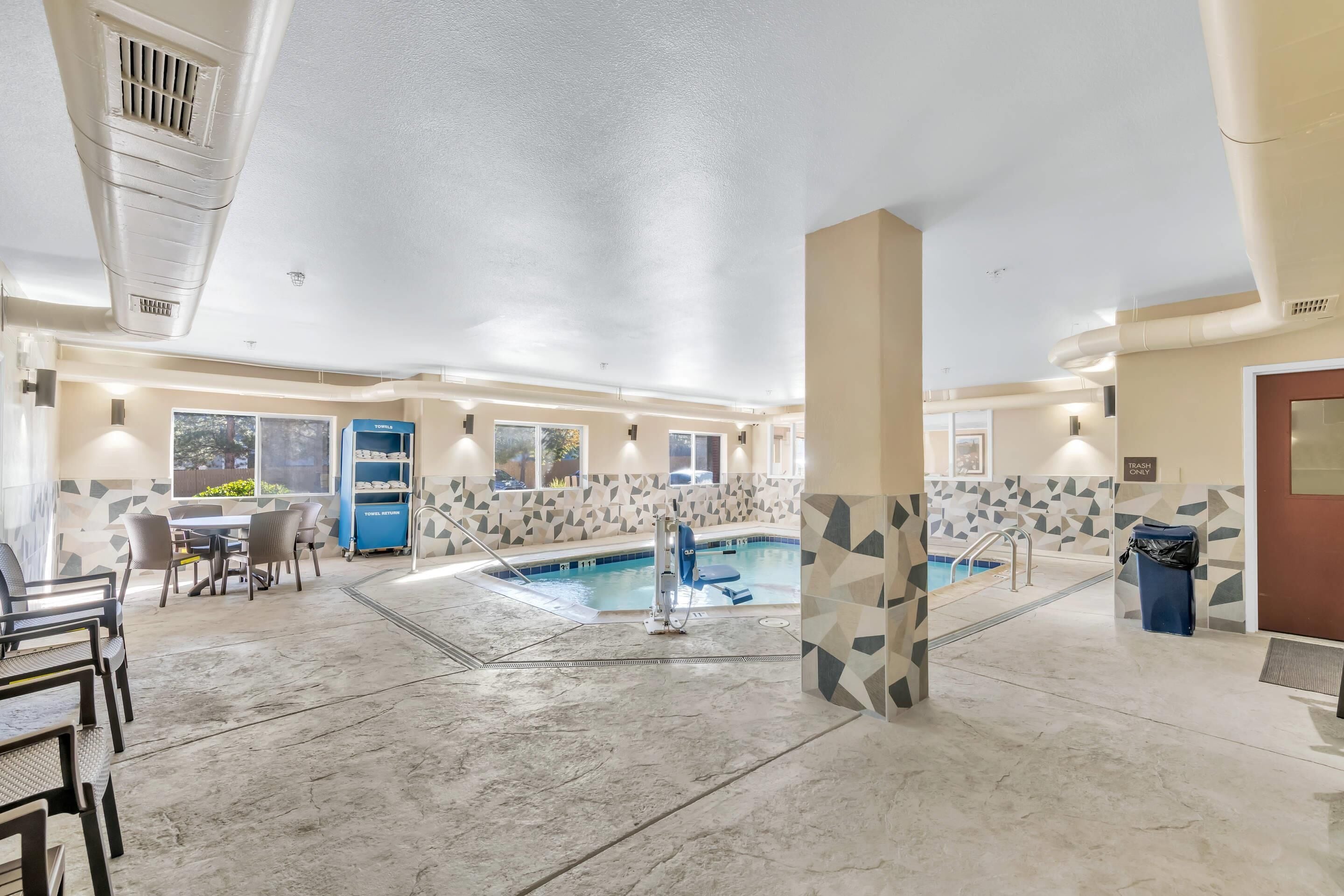 A hotel lobby with a pool, a reception desk, and a trash bin.