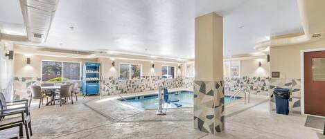 A hotel lobby with a pool, a reception desk, and a trash bin.