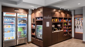A self-service market area with refrigerated beverage dispensers and shelves stocked with snacks and beverages. - Residence Inn by Marriott Denver Southwest/Lakewood (Lakewood)