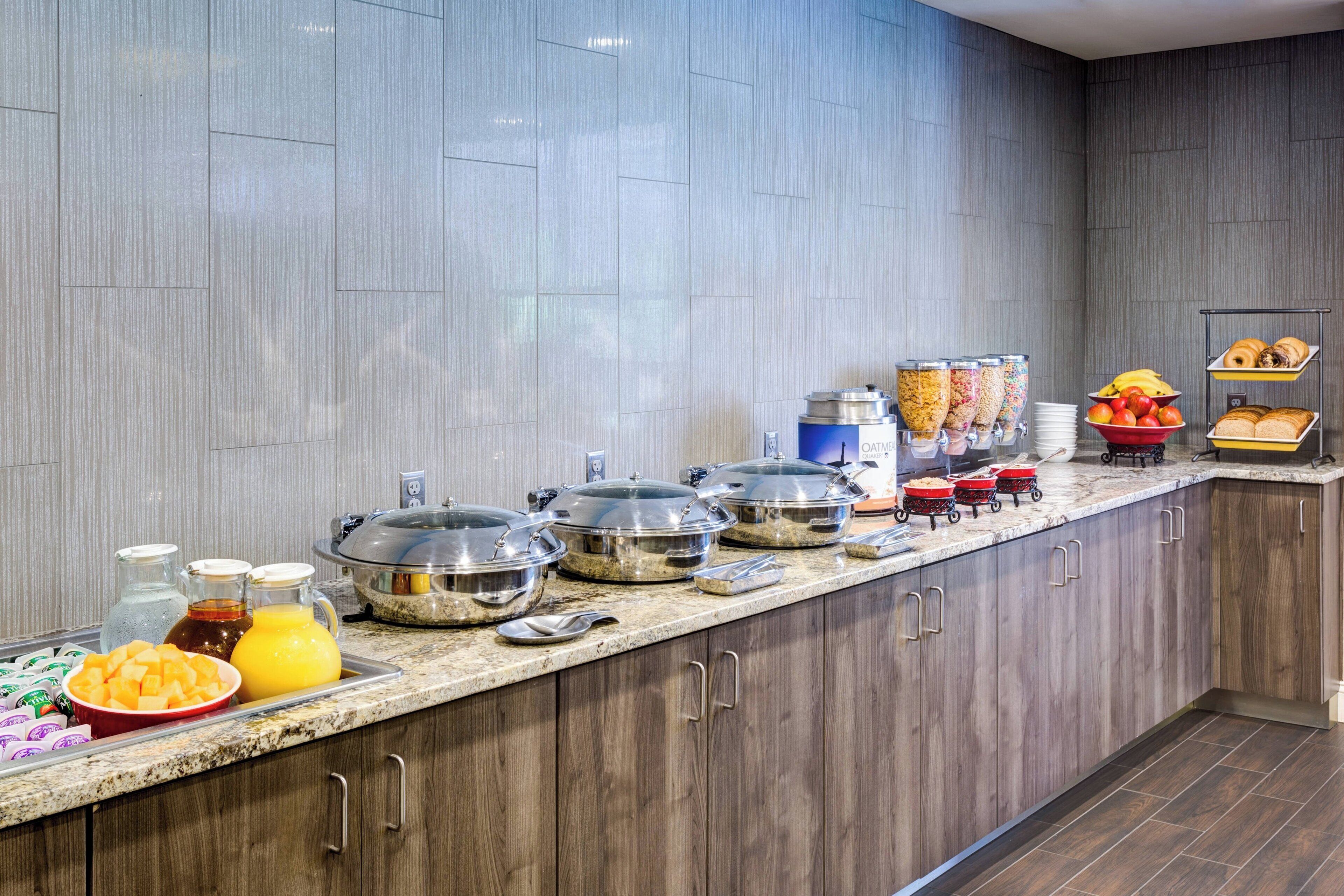 A buffet setup with various food items and containers.