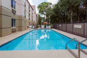 Una piscina al aire libre, tumbonas