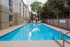 Una piscina al aire libre, tumbonas