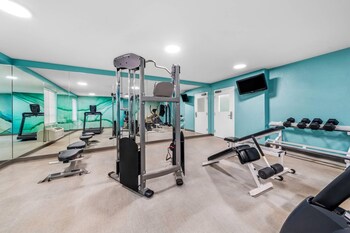 A swimming pool adjacent to a multi-story building with balconies and windows. at MainStay Suites Orlando Altamonte Springs