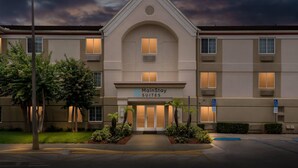 A hotel with a central entrance, multiple windows, and a sign reading 'MainStay Suites.'
