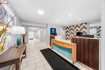 A gym with exercise equipment, a mirror, teal walls, and a television. at MainStay Suites Orlando Altamonte Springs