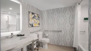Un baño moderno con lavamanos, inodoro y ducha de mármol.