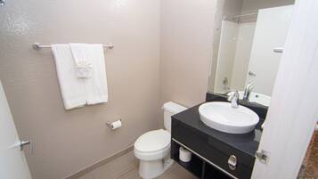 A small, clean bathroom with a toilet, sink, and towel rack.