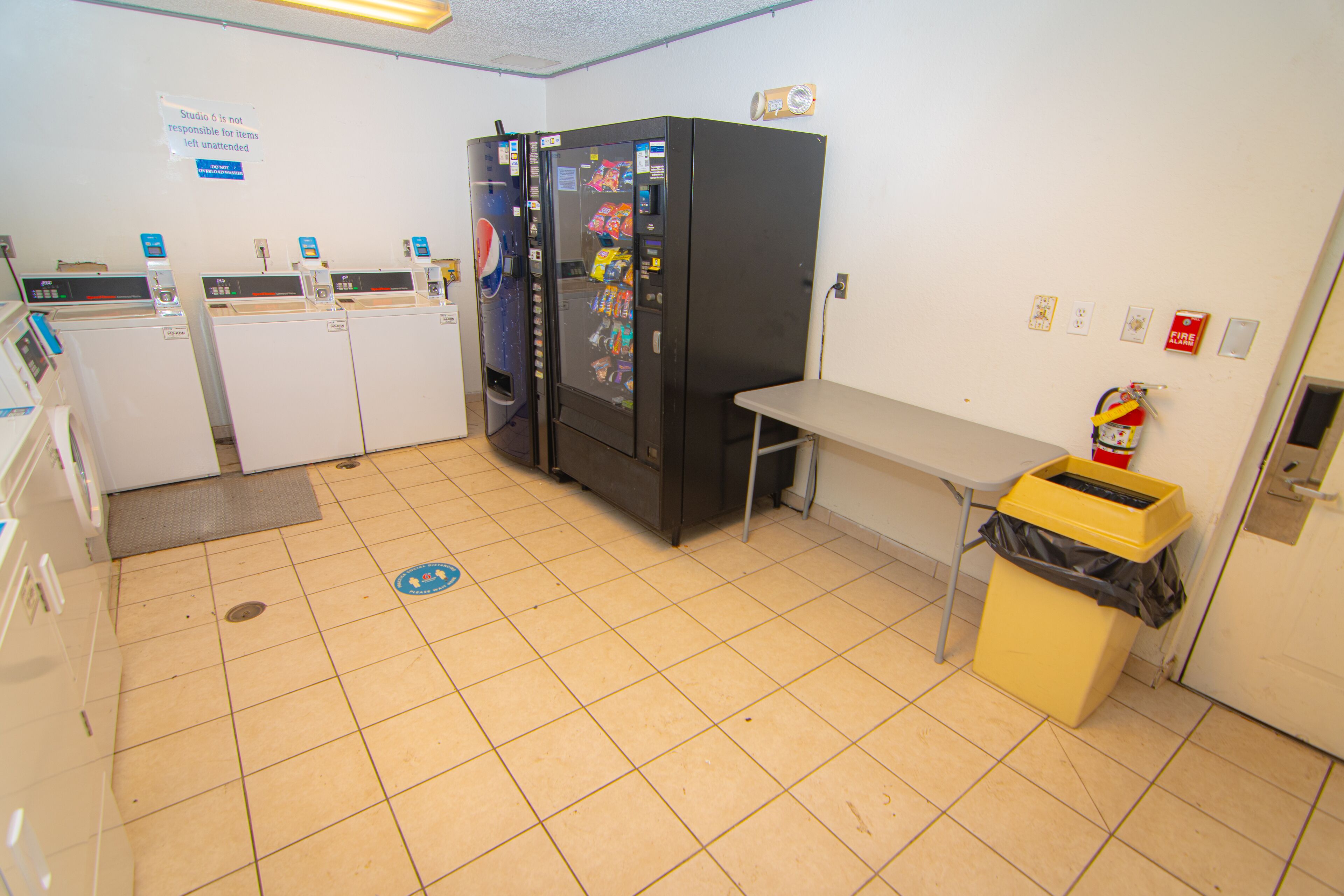 Een kleine kitchenette met een koelkast, magnetron en gootsteen.