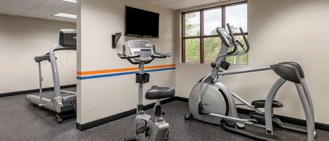A gym with treadmills, an elliptical, and a stationary bike.