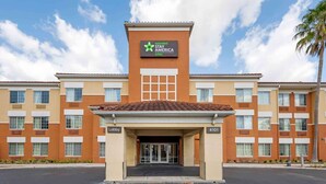 A hotel entrance with a sign for Extended Stay America suites, a lobby area, and a parking lot. - Extended Stay America Select Suites Orlando Southpark (Orlando)