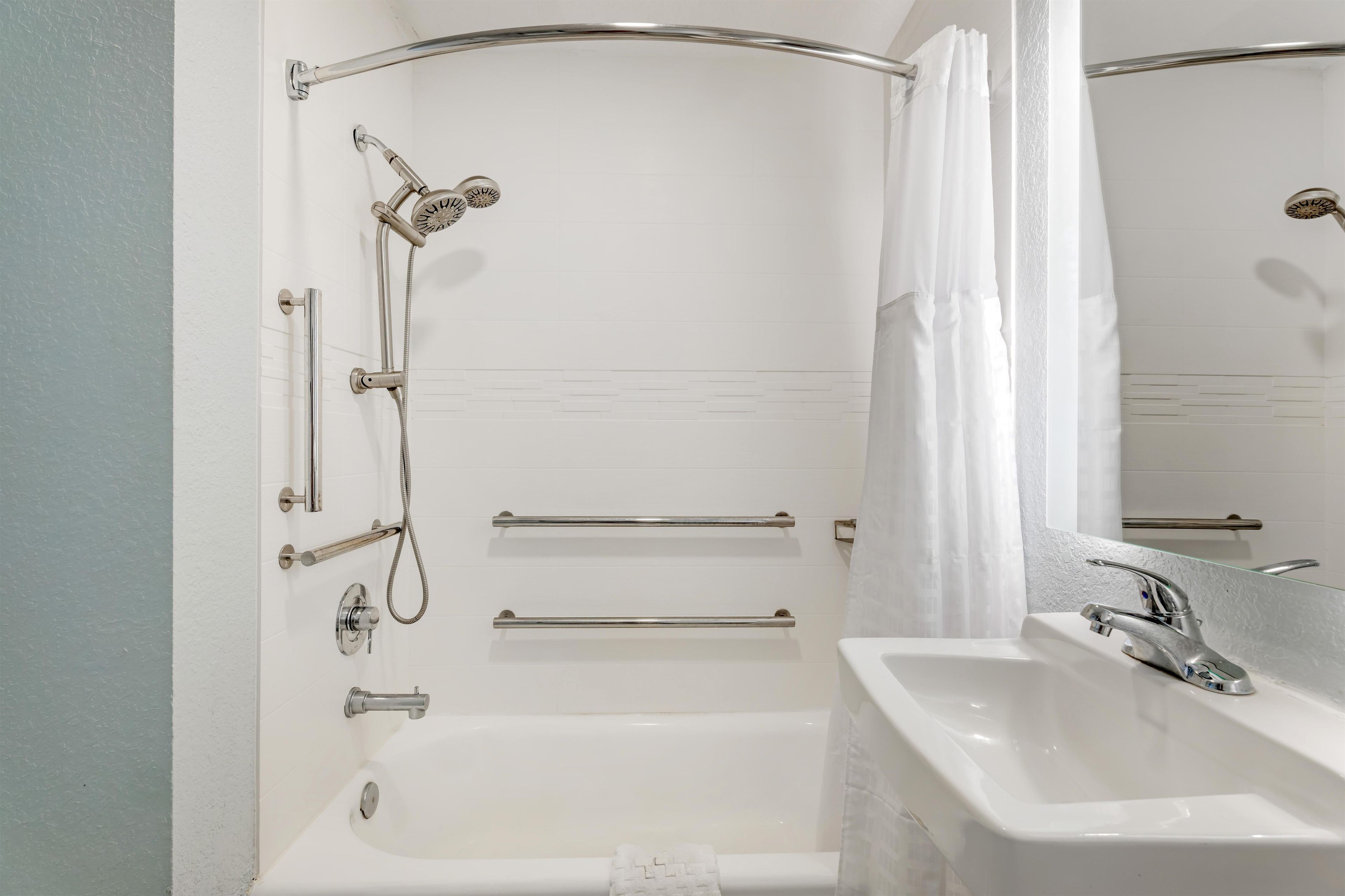 A bathroom with a bathtub, a sink, and a shower.