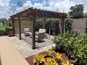 A covered patio area with outdoor furniture and a pergola. - Best Western Plus Orlando East- UCF Area  (Orlando)