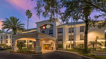 A hotel entrance with a sign reading 'Best Western PLUS,' featuring a modern architectural style with a flat roof and large windows.