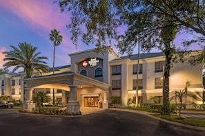 Entrada de un hotel con un cartel que dice 'Best Western PLUS', que presenta un estilo arquitectónico moderno con techo plano y ventanas amplias.