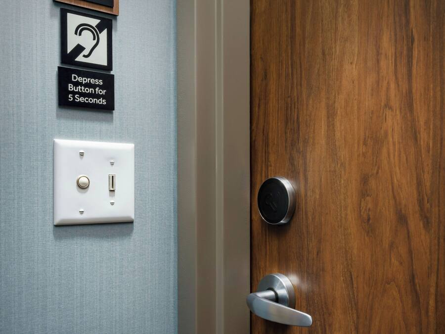 A door with a modern lock and a wall-mounted switch.