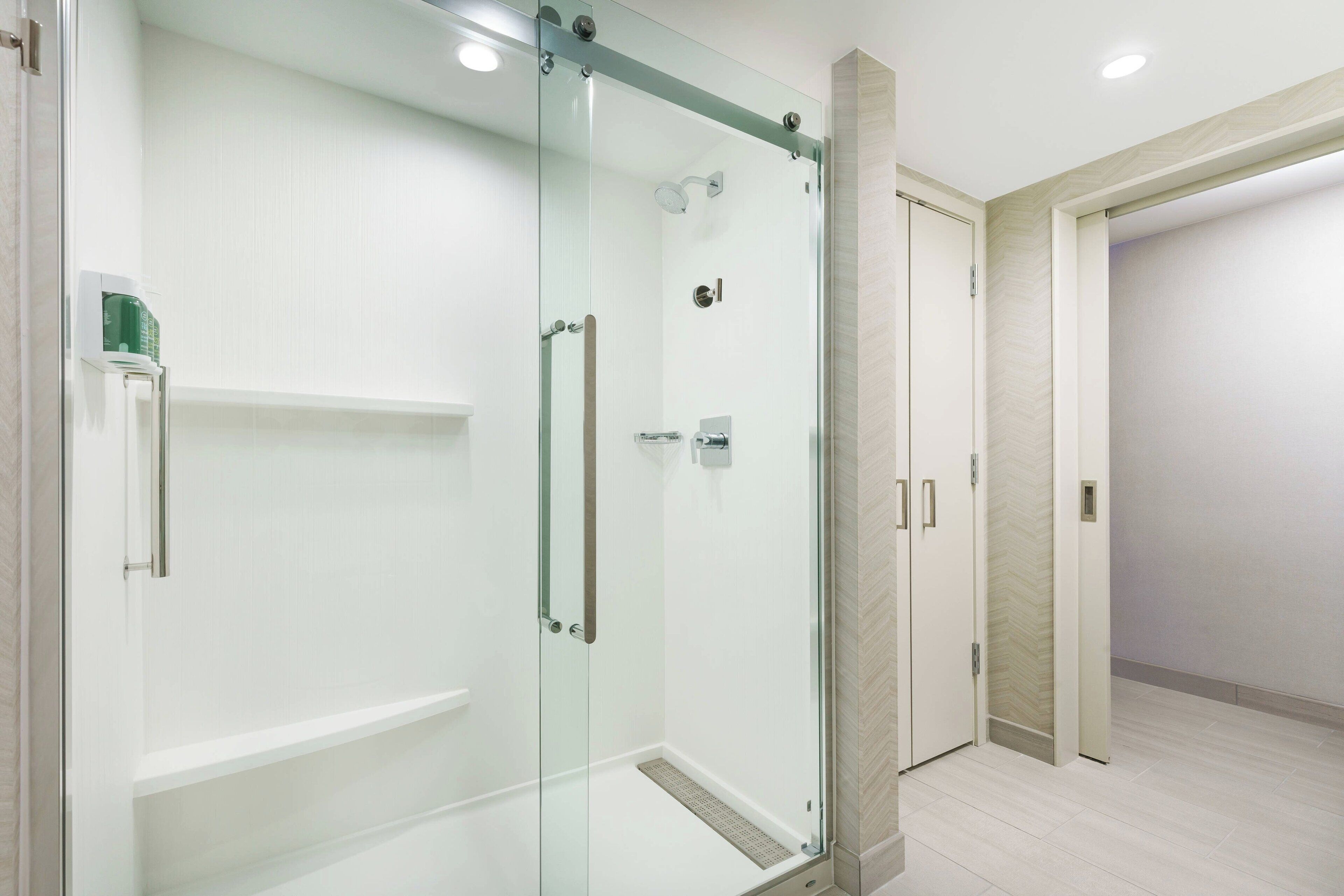 A modern bathroom with a glass-enclosed shower, a toilet, and a sink.