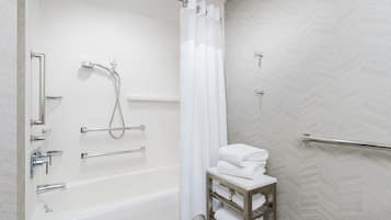 Un baño moderno con bañera, ducha y perchero.