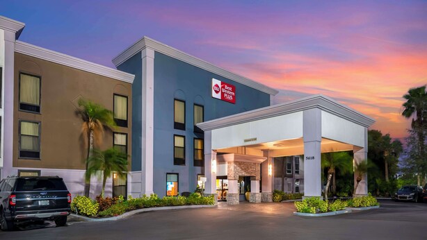 A hotel with a 'Best Western Plus' sign, a covered entrance, and a parking lot with cars. - Best Western Plus Universal Inn (Orlando)