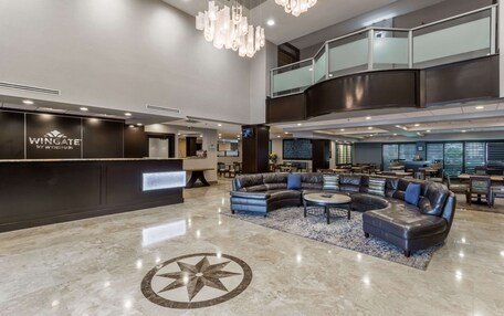 A spacious lobby with a reception desk, leather sofas, and a large star-patterned floor design.