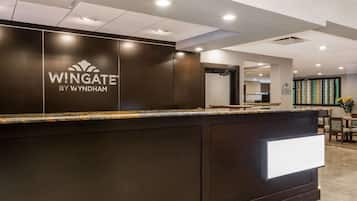 A reception desk with a dark wood finish and a marble top.