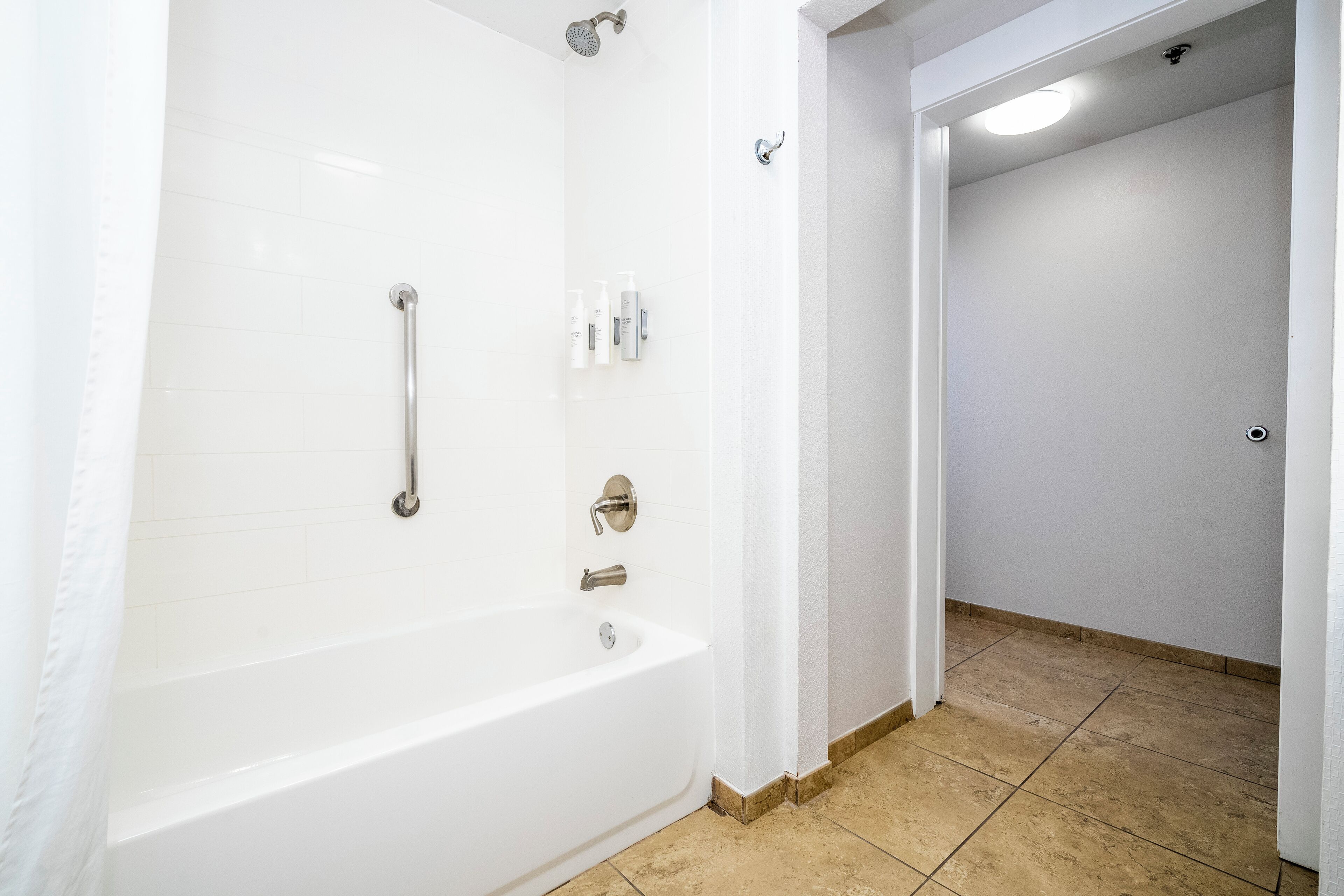 Een badkamer met een bad, een douche en een toilet.