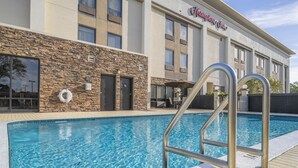 Un hotel con piscina, fachada de piedra y un letrero que dice "Chumley Inn".
