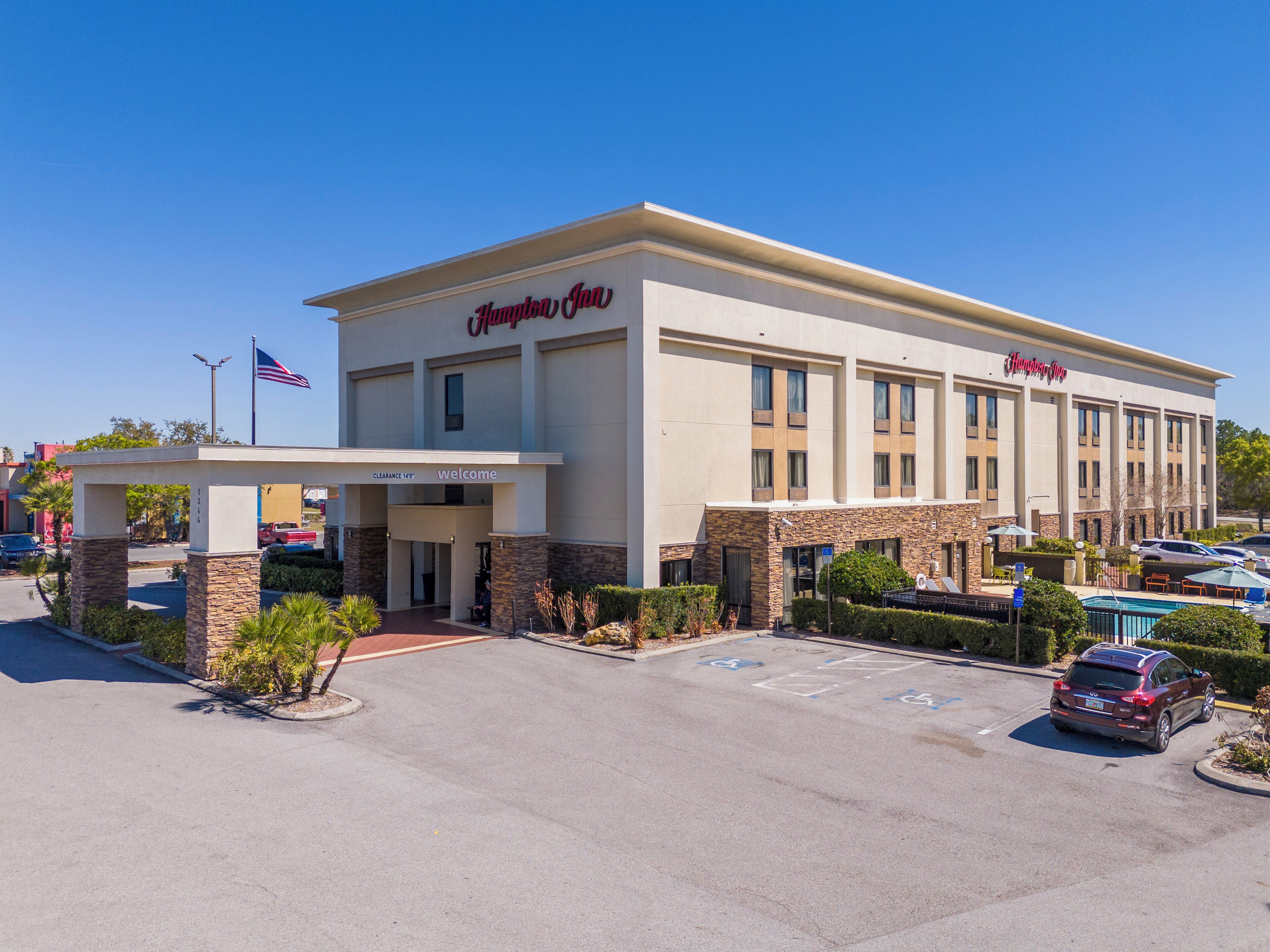 A Hampton Inn hotel with a clear entrance, a parking lot, and a swimming pool.
