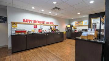 Ein Frühstücksbereich mit einer Theke, Küchengeräten und einem Schild mit der Aufschrift 'HAPPY BREAKFAST STARTS HERE'.