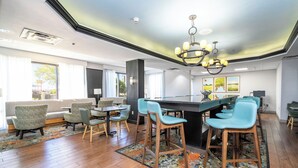 Una habitación amplia con una gran mesa de comedor, varias sillas y una zona de bar.