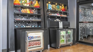 Un área de máquinas expendedoras con aperitivos y bebidas, y dos vitrinas refrigeradas con refrescos.