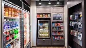 Una tienda de conveniencia bien iluminada con estantes llenos de botanas, bebidas y artículos para el hogar.