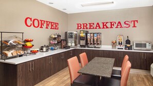 A breakfast area with a coffee station, seating, and a microwave. - Ramada by Wyndham Alpharetta/Atlanta North (Alpharetta)