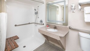 A bathroom with a bathtub, a sink, a mirror, and a toilet. - Ramada by Wyndham Alpharetta/Atlanta North (Alpharetta)