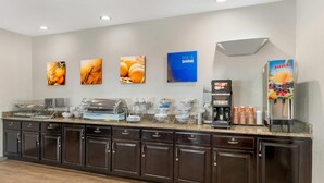 A breakfast bar with a coffee machine, juice dispenser, and various food items. - Comfort Inn Blairsville Butternut Creek (Blairsville)