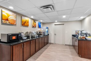 A modern kitchen with a microwave, toaster, and coffee maker, and a door leading to another room. - Comfort Inn Douglasville - Atlanta West (Douglasville)
