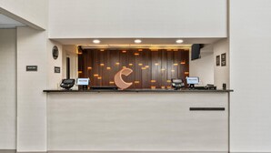 Ein Empfangsschalter mit modernem Design, einer Halbmond-Form und zwei Computerarbeitsplätzen.