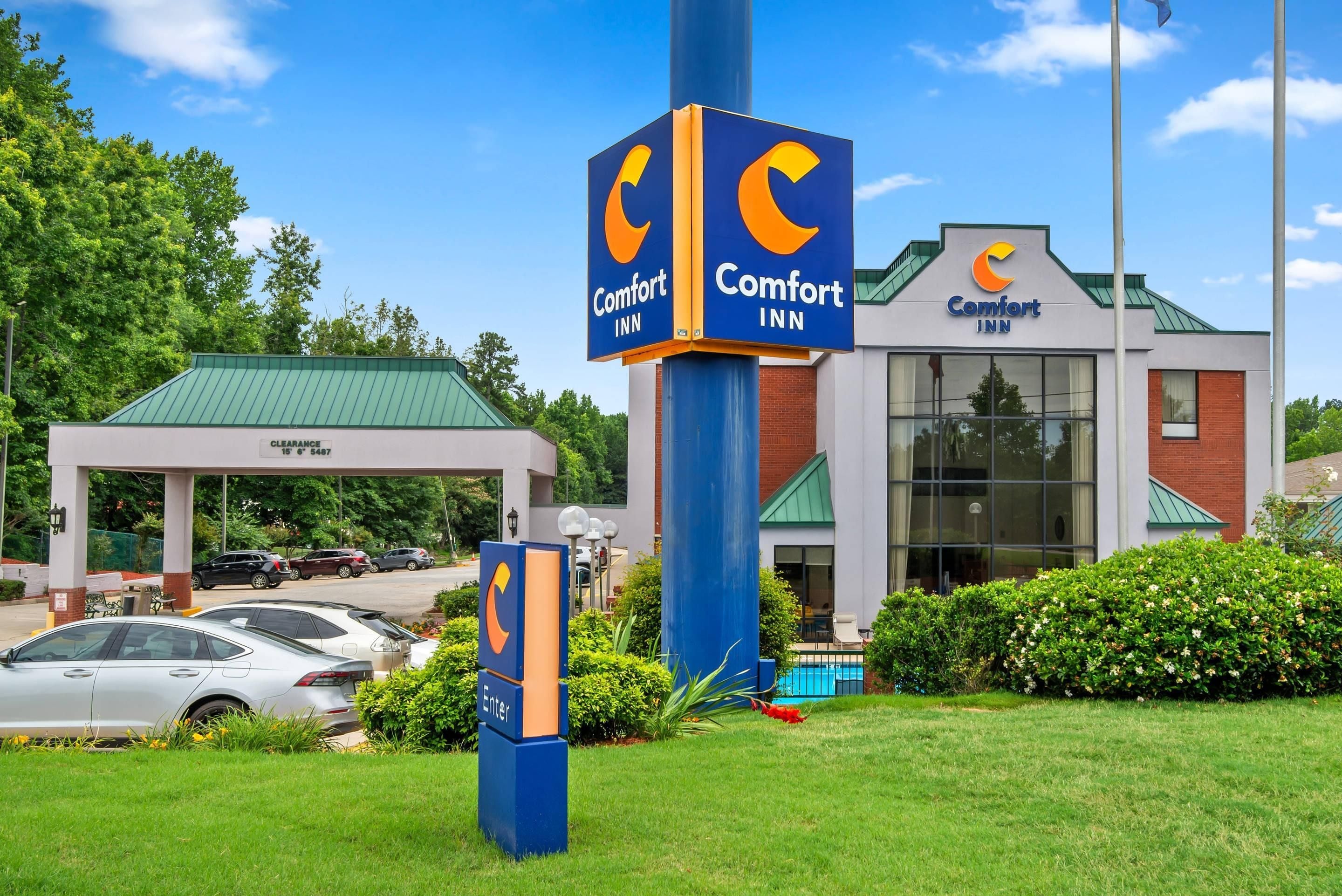 Ein Comfort Inn Hotel mit freiem Zugang, einem überdachten Parkbereich und einem Schwimmbad.