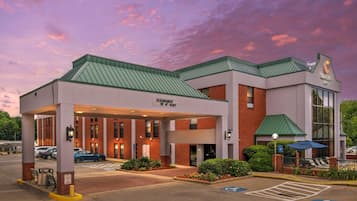 A Comfort Inn with a covered entrance, a parking lot, and a clear sky.