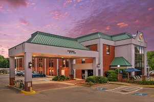 A Comfort Inn with a covered entrance, a parking lot, and a clear sky.
