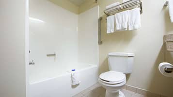 A bathroom with a bathtub, toilet, and towel rack.