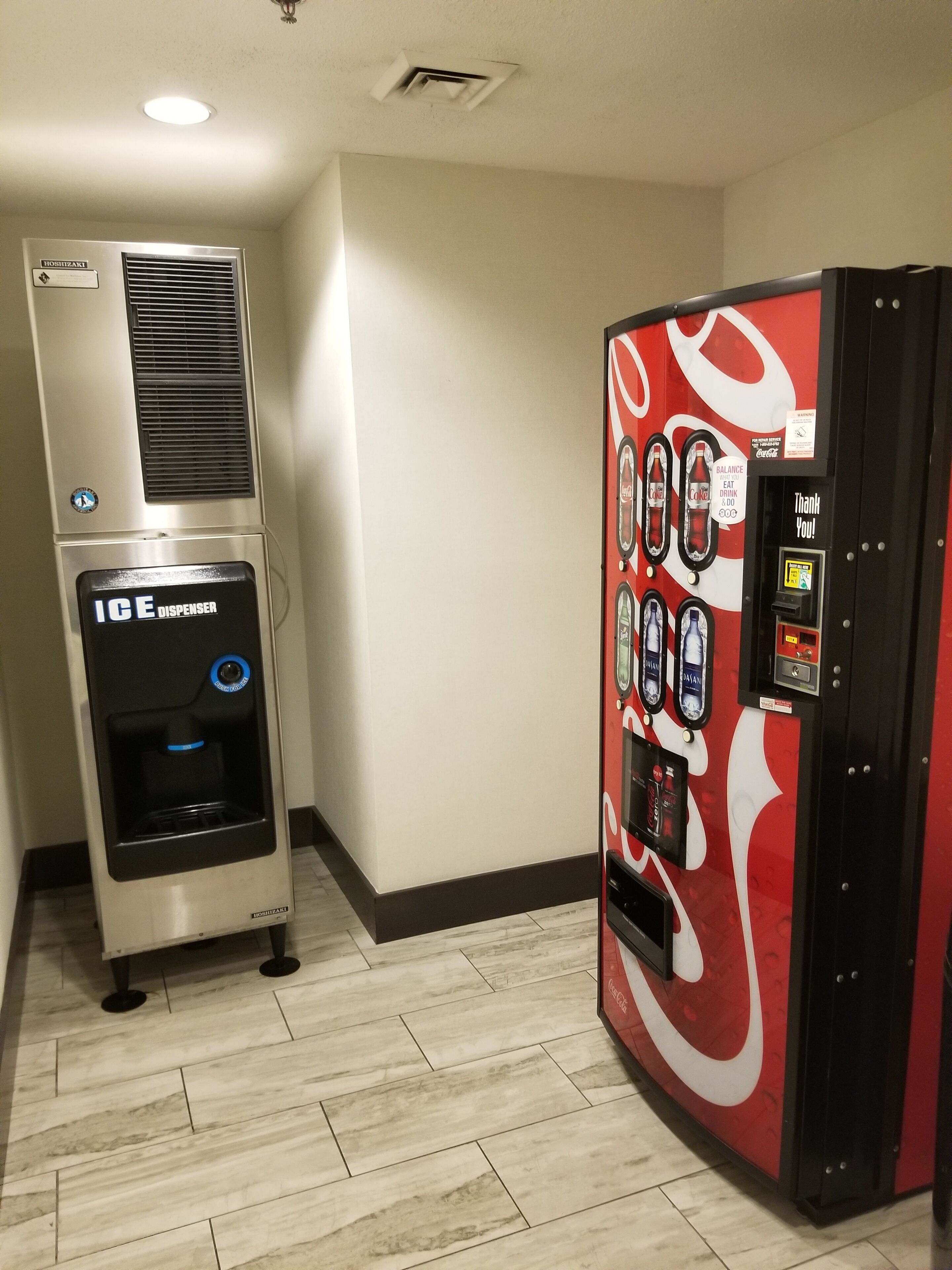 A vending machine with a Coca-Cola logo and a Coca-Cola branded drink dispenser.