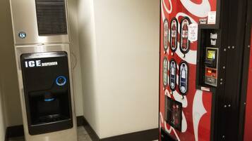 A vending machine with a Coca-Cola logo and a Coca-Cola branded drink dispenser.