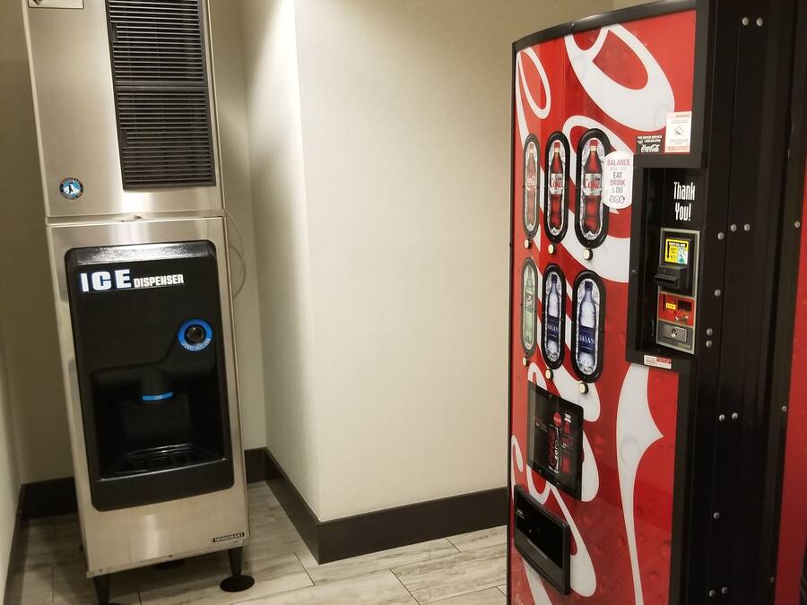 Una máquina expendedora con el logotipo de Coca-Cola y un dispensador de bebidas de Coca-Cola.