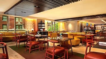 A modern restaurant with high ceilings, exposed brick walls, and a mix of seating options including tables and booths.