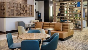 Un hall d’entrée moderne avec un espace salon, un téléviseur et un mur décoratif.